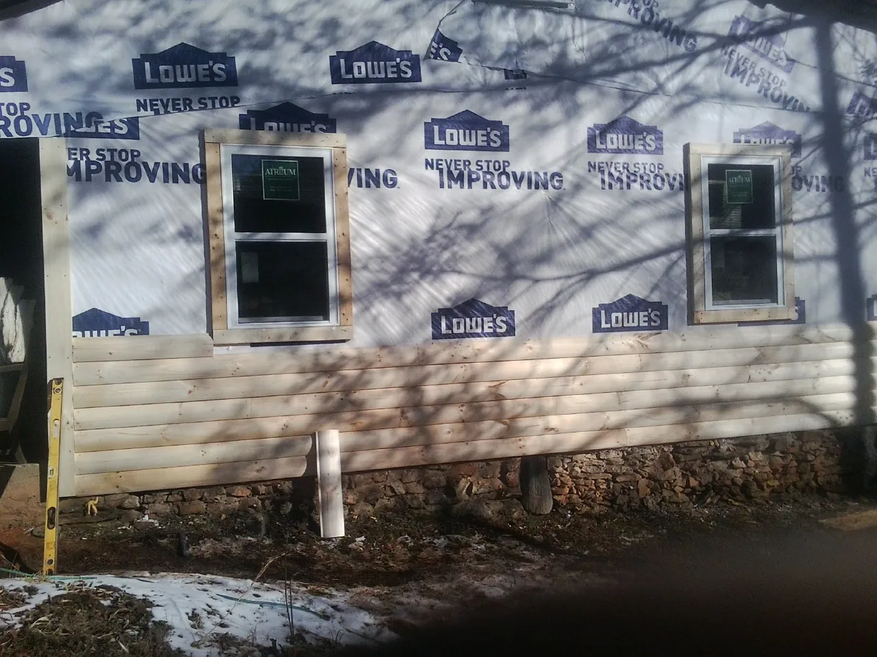 House wrap and new log siding going up on an exterior wall in Carencro