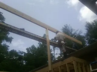 Carpenter setting a ridge beam over a new addition frame — Ice Dam Removal by Roofing Brothers in Carencro