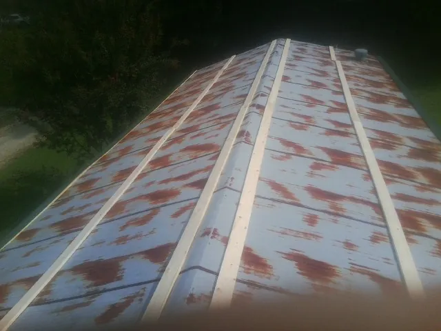 Rusted metal roof panels with new wood purlins before replacement — Storm Damage Roof Repair in Carencro by Roofing Brothers