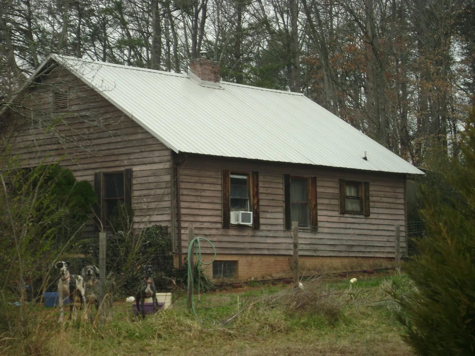 White metal roof on an old wood sided farmhouse, from a Metal Roof Installation job in Carencro
